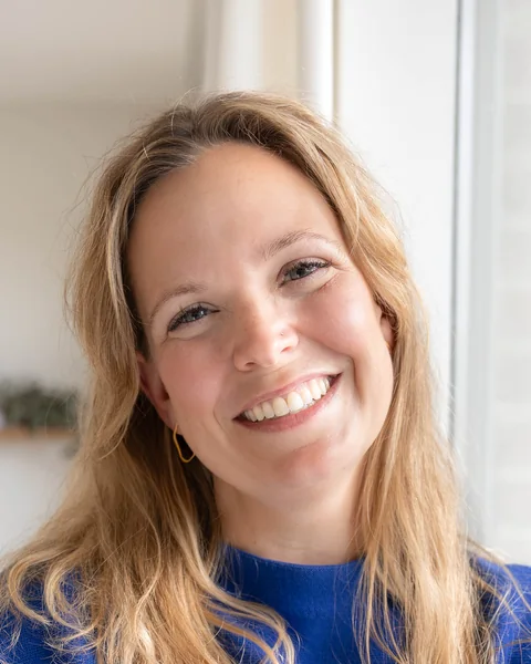 Portret van Lies Theuwissen, lachend, in een blauwe trui.